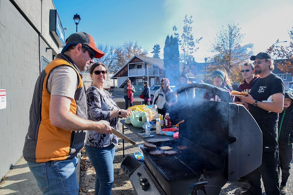Salmon Arm Observer’s publisher Andrea Horton and spouse Craig serve burgers during the carrier appreciation BBQ on Saturday, Oct. 27. (Cameron Thomson/Salmon Arm Observer)