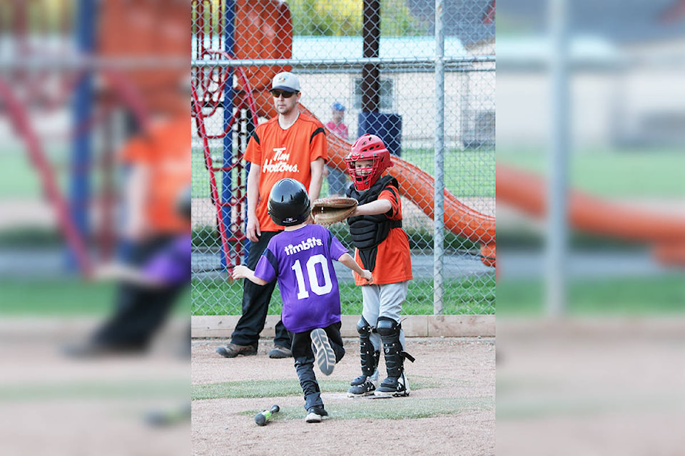 Carter Metz, number 10 on Team Purple, runs for home plate where catcher Caleb Gawley of The Orange Tigers awaits. The teams tied 9-9 on June 1, 2021. (Rebecca Scott-Contributed)