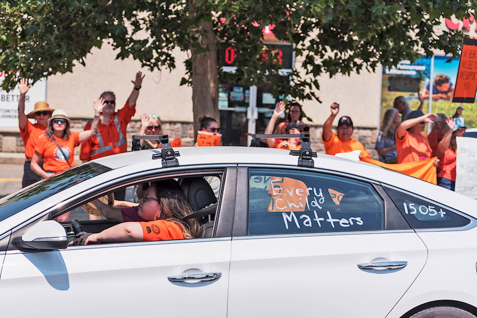 A caravan, or rolling blockade of vehicles, on its way to the former Kamloops Indian Residential School, receives waves and shouts of support as it passes through downtown Salmon Arm along Highway 1 about noon on July 1. (Lachlan Labere - Salmon Arm Observer)