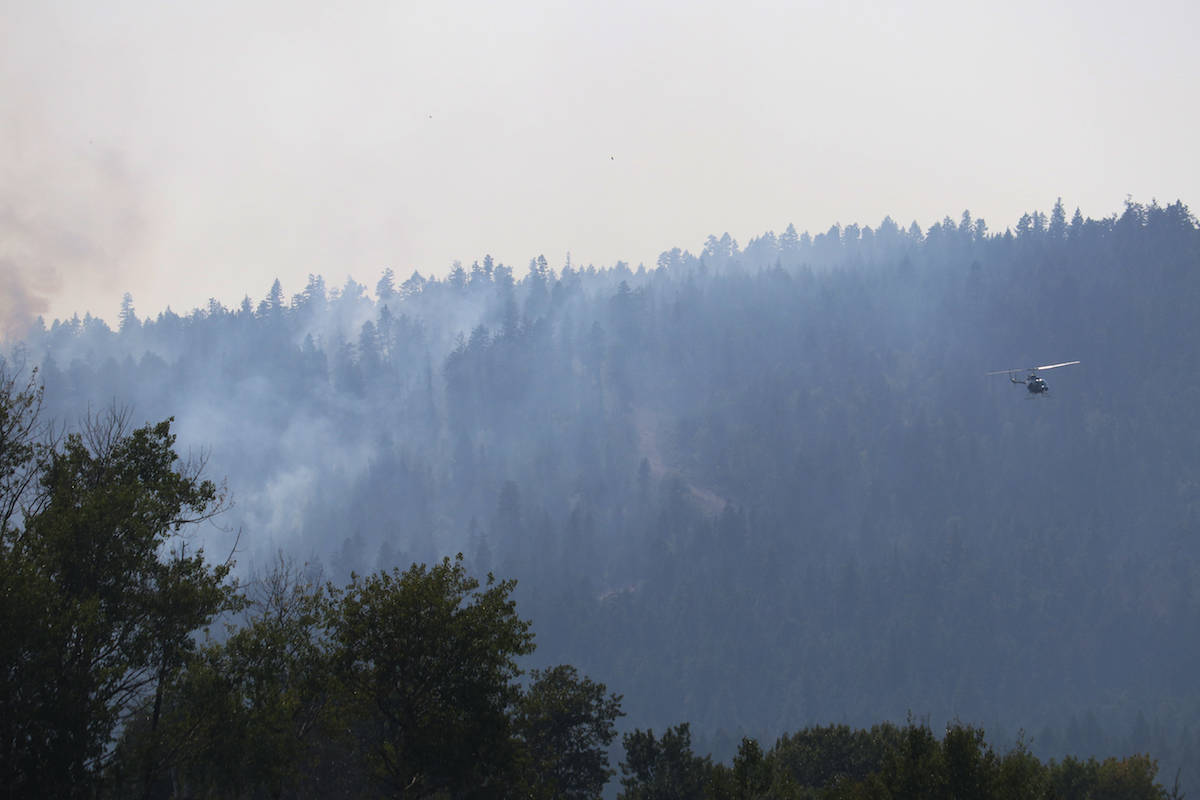 A helicopter surverys the Mount Law wildfire, just above Preston Road and Glonrosa Road in West Kelowna on Wednesday, Aug. 18. (Aaron Hemens/Capital News)