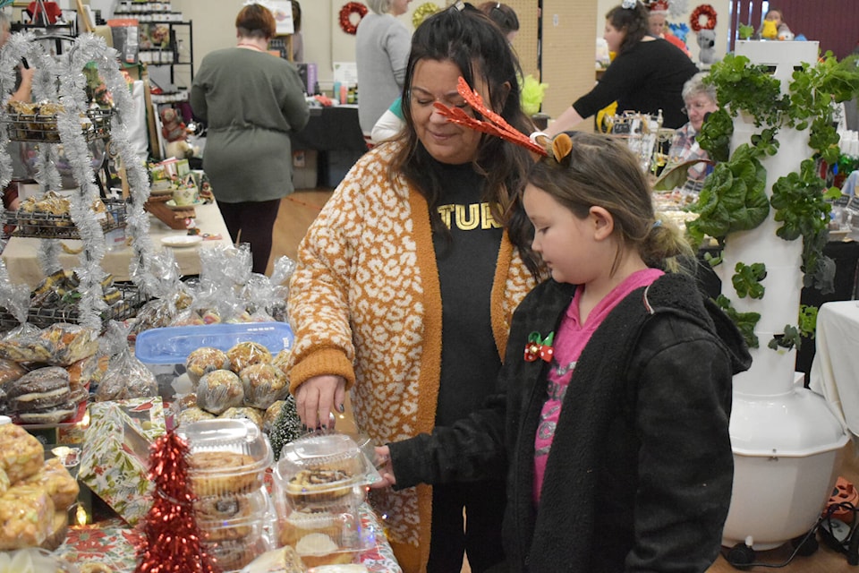 Meredith and Calista Rusk buying sweet treats at the Tappen Tarts table at the Christmas A-Fair at the Salmon Arm Seniors Centre, Dec. 10 2022. (Rebecca Willson/ photo)