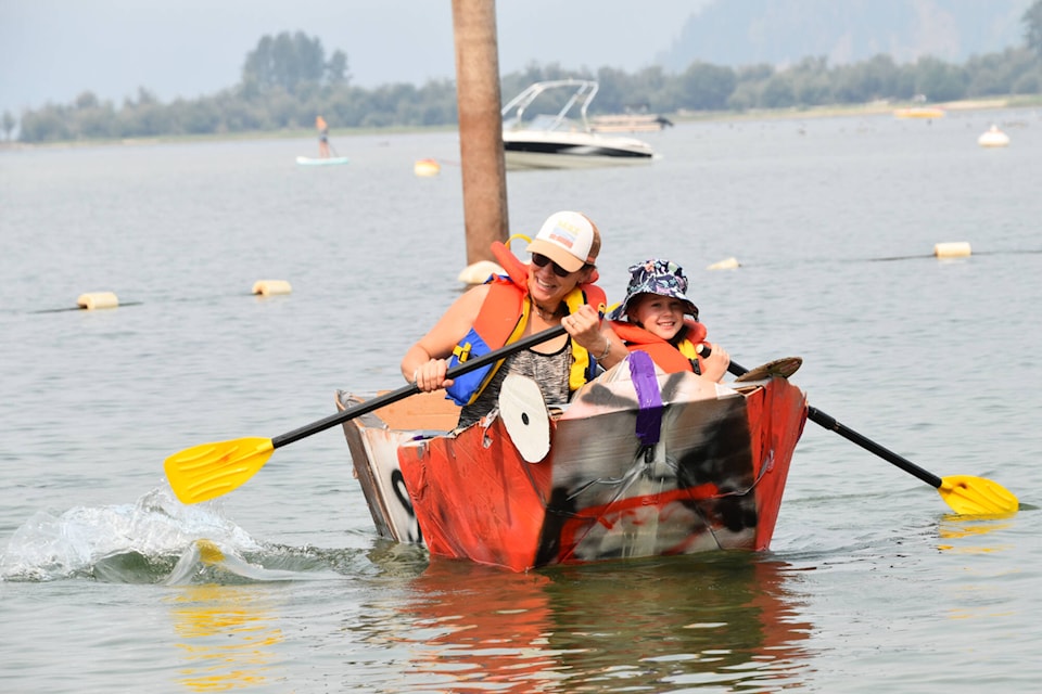 Sara Mitchell and Cassidy Baker paddle their cardboard boat at Sicamous Family Fun Day Saturday, Aug. 5, 2023. (Rebecca Willson-Eagle Valley News)