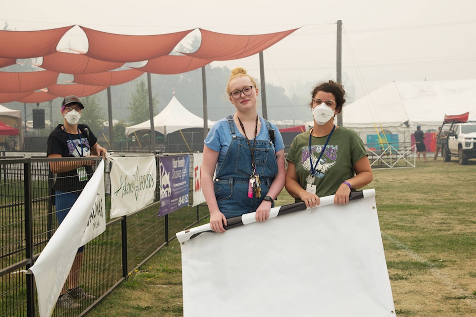 At right, Althea Mongerson, sponsorship marketing coordinator with the Salmon Arm ROOTSandBLUES Festival, gives a hand Aug. 19 to volunteer coordinators Jasmine Skubiak, next to her, and Emily Valentini as they take down banners. (Martha Wickett photo)