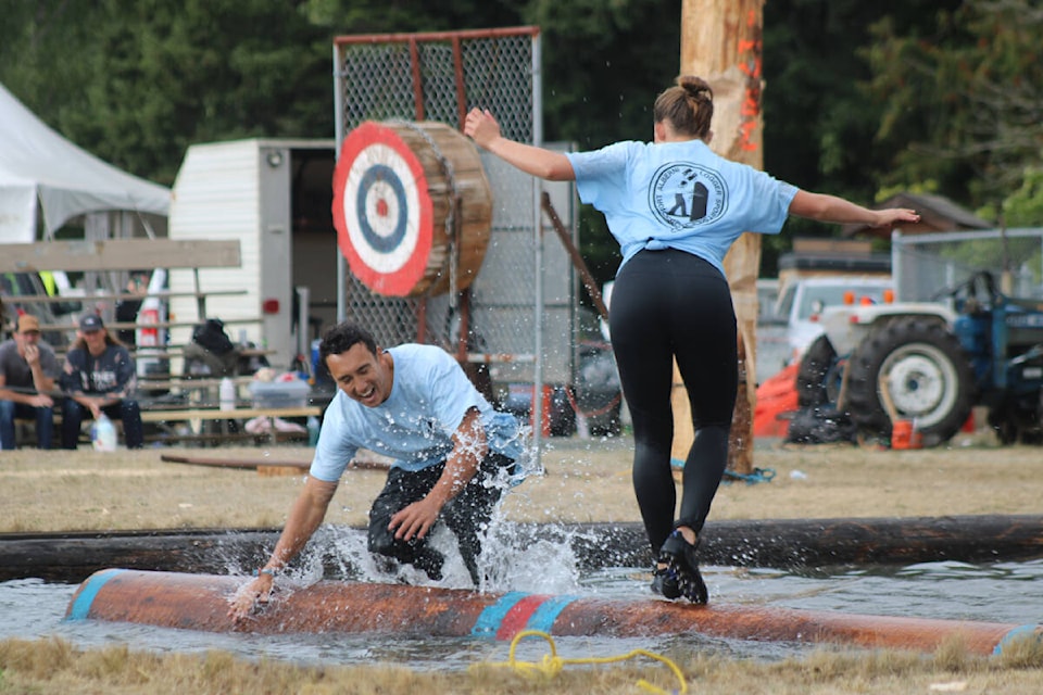 Sean Yokoyama takes a spill against one of the top female logger sports athletes in the world in the log birling event at the Alberni District Fall Fair logger sports on Sunday, Sept. 10, 2023. (SONJA DRINKWATER/ Special to the AV News) 