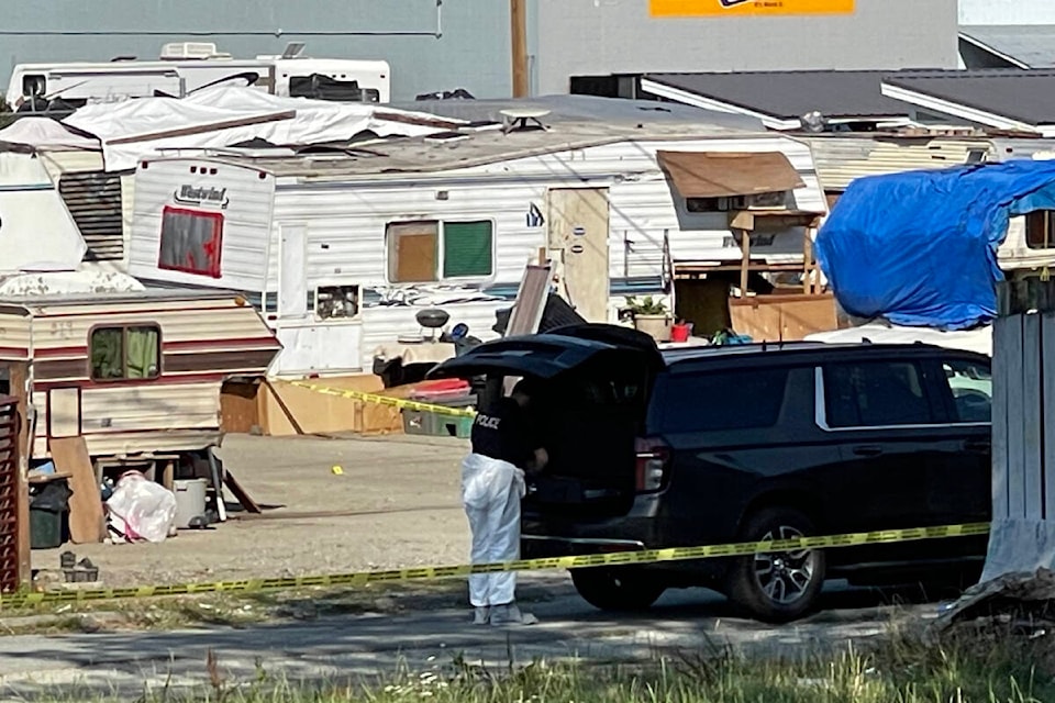 An RCMP forensics team gathers evidence from a trailer parked behind the Wintergreen Apartments on Fourth Avenue in Port Alberni on Sept. 1, 2023 following an early-morning targeted shooting. (SUSAN QUINN/ Alberni Valley News) 