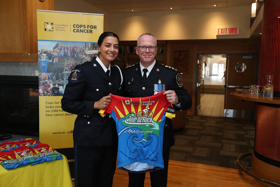 Nadia Sandhu with the Saanich Police Department receives her jersey from Deputy Chief Constable Robert Warren Friday (Sept. 8) during the last official event before the 1,200 km ride begins Sept. 23. (Justin Samanski-Langille/News Staff) 