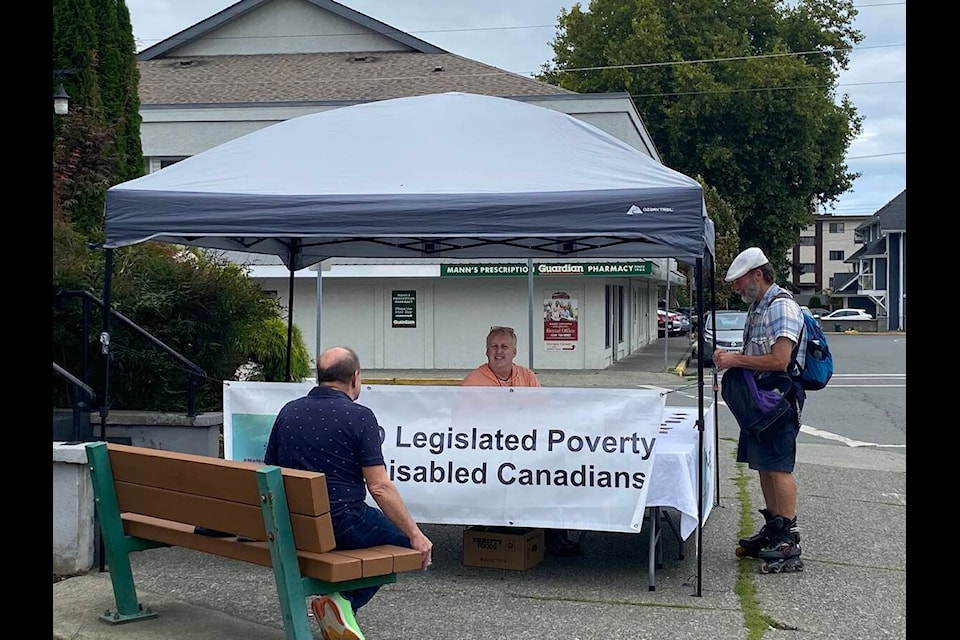 Disability advocate Jeff Leggat of Duncan speaks to community members about the effects of legislated poverty in Canada and how disabled Canadians deserve better. Leggat had his booth set up in front of Duncan United Church on Sept. 6 before embarking on his Western Canada tour from Sept. 7 to 16. (Chadd Cawson/Citizen) 