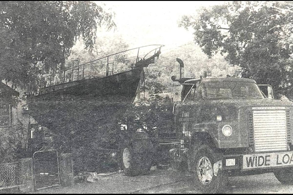 ”Tight squeeze as about eight tons of steel boat is eased into gap in hedge. Trees were temporarily removed and replanted a few hours later with sailboat snugly in place, virtually screened from main street.” (Lake News/Sept. 14, 1983) 