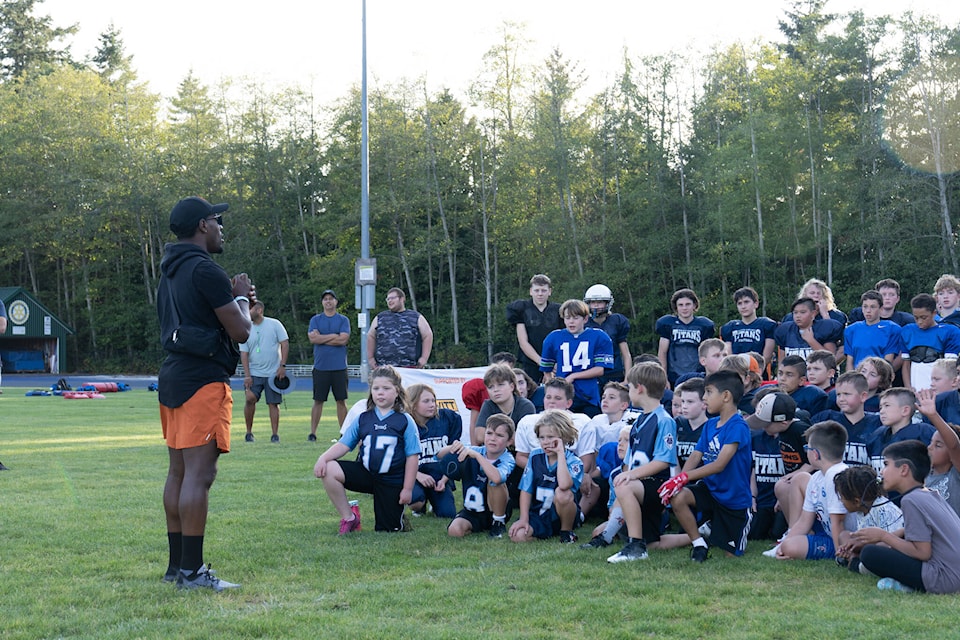 BC Lions defensive back TJ Lee talks with White Rock South Surrey Titans Minor Football Association players at their practice on Tuesday night (Sept. 5). (Garry Dosa photo) 