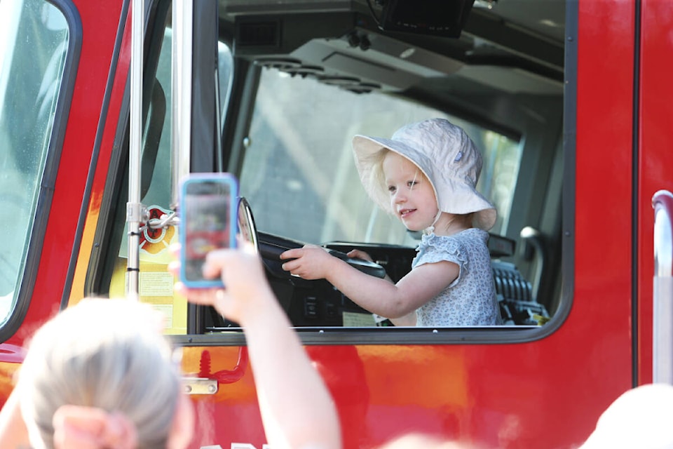 Summer Smithson, 3, has her picture taken while sitting inside a firetruck Saturday (Sept. 16) during the Saanich police and fire departments’ open house. (Justin Samanski-Langille/News Staff) 