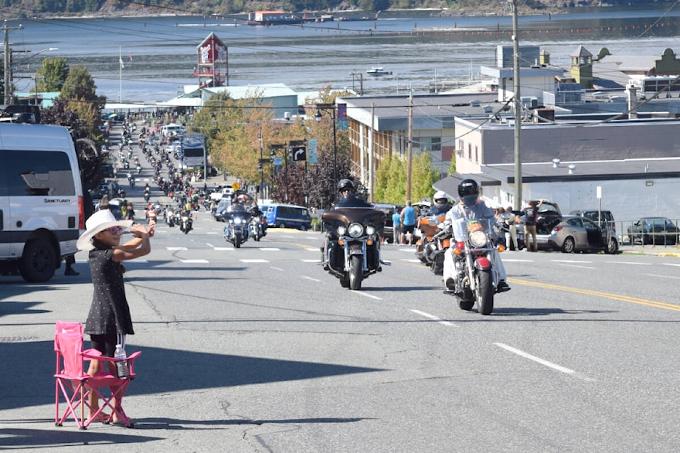 A young spectator waves to the bikes in the Port Alberni Toy Run as they cruise up Argyle Street. (ELENA RARDON / Alberni Valley News) 