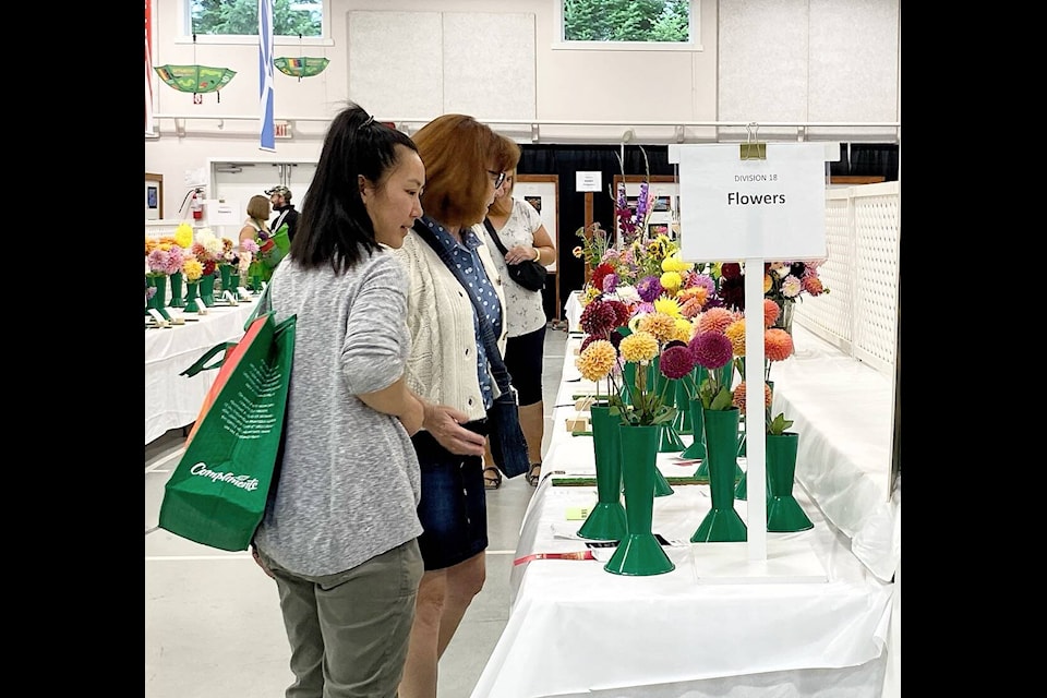 Some ladies take in the beauty of some of the award winning flowers in Mellor Hall at the Cowichan Exhibition on Sunday, Sept. 17. (Chadd Cawson/Citizen) 