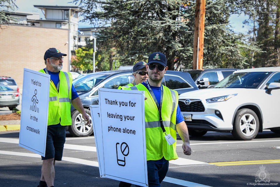 Members of the Road Safety Target Team and Ridge Meadows RCMP volunteers were out patrolling popular Maple Ridge intersections on Sept. 20 as part of the Messages in Motion campaign. (Ridge Meadows RCMP/Special to The News) 