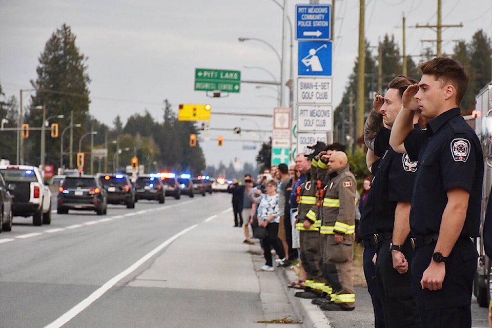 First responders – one BC Emergency Health Services worker and 17 members of Pitt Meadows Fire and Rescue – lined Lougheed Highway by Harris Road, to salute a motorcade of police vehicles escorting a fallen officer through the city into Maple Ridge. (Colleen Flanagan/The News) 