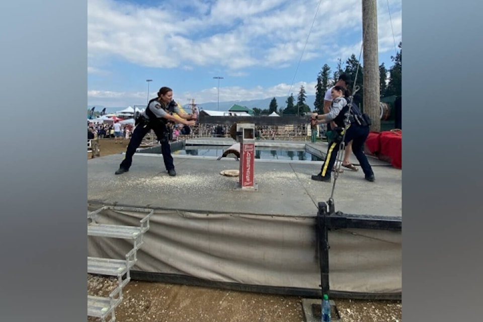 Vernon North Okanagan RCMP constables Chelsey Valotaire (left) and Amanda Taylor engage in a sawing competition during the 2023 Interior Provincial Exhibition in Armstrong. (RCMP Photo) 