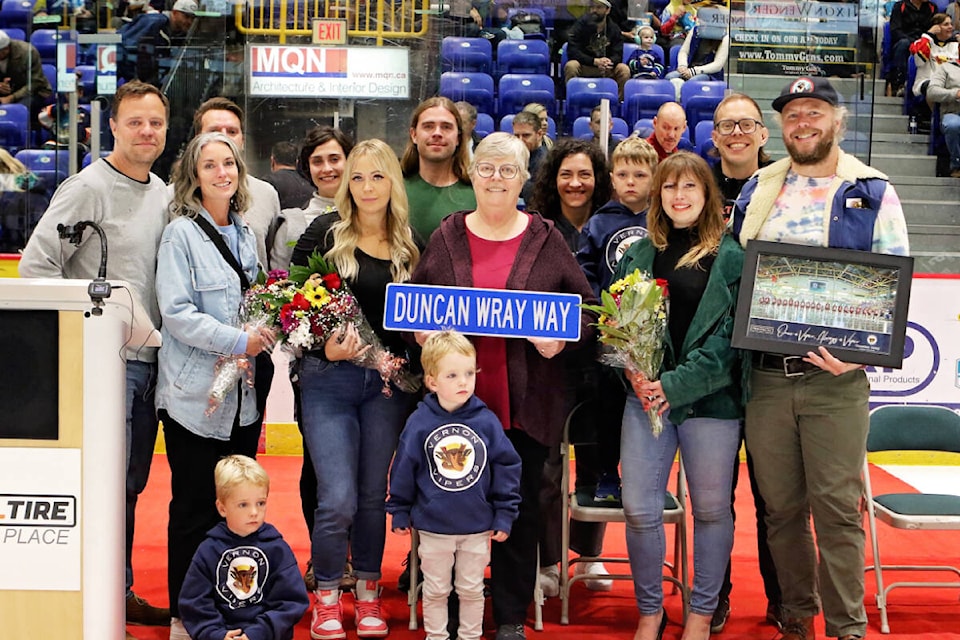 Later former Vernon Vipers team owner Duncan Wray’s family gathers for a photo at centre ice prior to the Snakes’ BCHL home opener Saturday, Sept. 23. The roadway into Kal Tire Place off 43rd Avenue has been named Duncan Wray Way, and his widow, Libby, holds the sign. A banner remembering Wray was raised to the rafters inside Kal Tire Place. (Lisa Mazurek - Vernon Vipers Photography) 