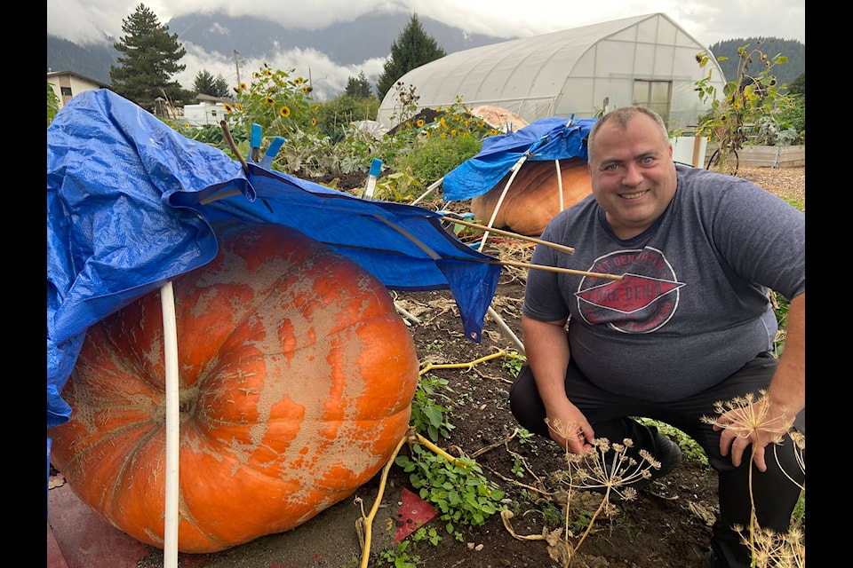 Barry Aubin poses with one of the two giant pumpkins he grew for the Giant Pumpkin Event. (Kemone Moodley/Hope Standard) 