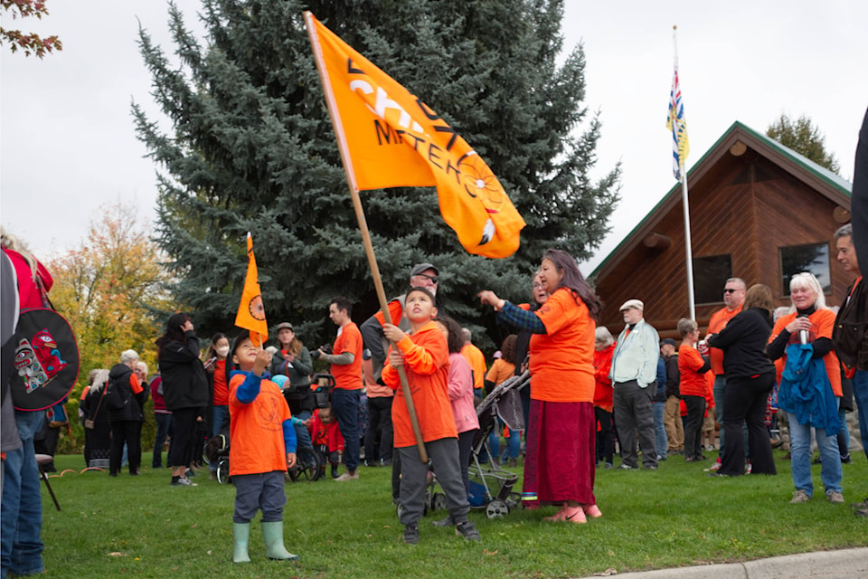 Brylan Sam and Dion Leon wave ‘Every Child Matters’ flags at the Splatsin Truth and Reconciliation walk on Saturday, Sept. 30, 2023. (Rebecca Willson-Eagle Valley News) 