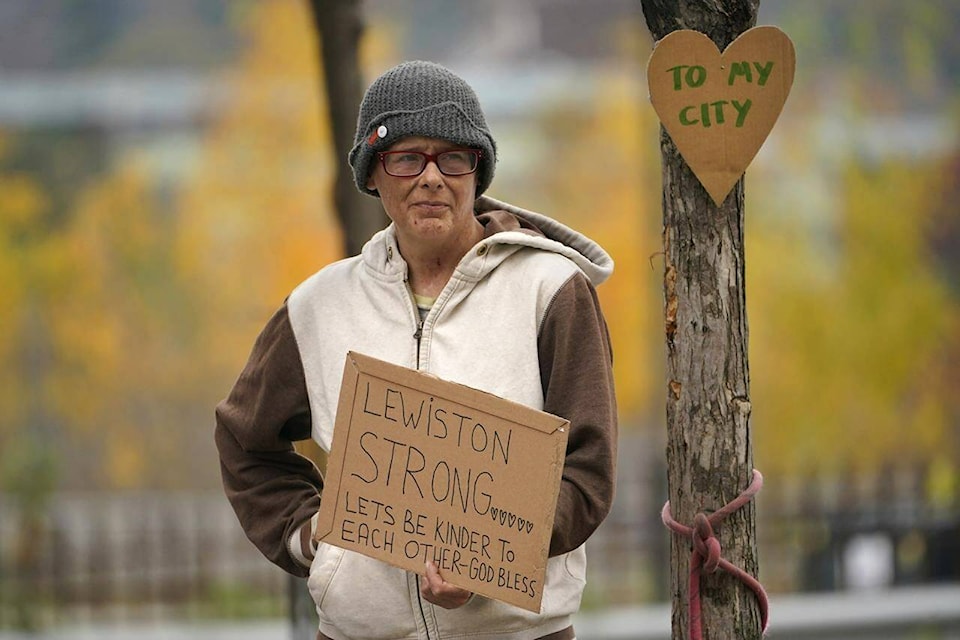 Jess Paquette expresses her support for her city in the wake of Wednesday’s mass shootings at a restaurant and bowling alley, Thursday, Oct. 26, 2023, in Lewiston, Maine. Police continue their manhunt for the suspect. Authorities urged residents to lock themselves in their homes and schools announced closures on Thursday. (AP Photo/Robert F. Bukaty) 