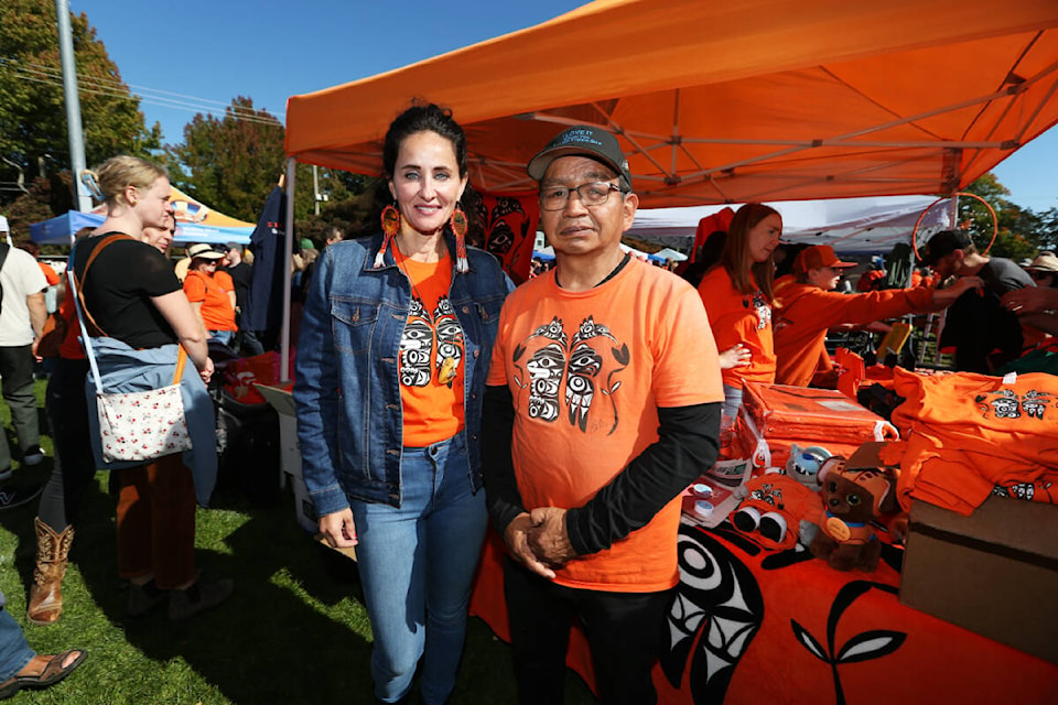 Victoria Orange Shirt Day co-founders Kristin Spray and Eddy Charlie stand in front of their vendor booth at the South Island Powwow Saturday (Sept. 30) at Royal Athletic Park in Victoria. (Justin Samanski-Langille/News Staff) 
