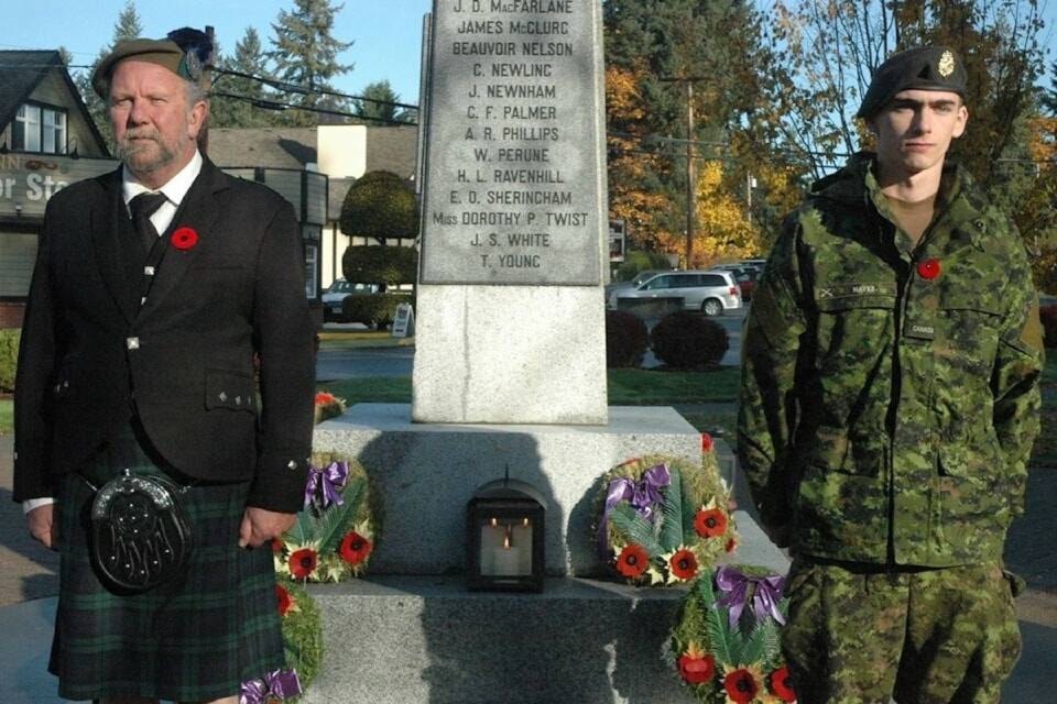 Cobble Hill’s Bob Collins (left) and reservist Keenan Hayes stand at attention at Cobble Hill Cenotaph to honour members of the Canadian military who died in Canada in non-combat roles. (Robert Barron/Citizen) 