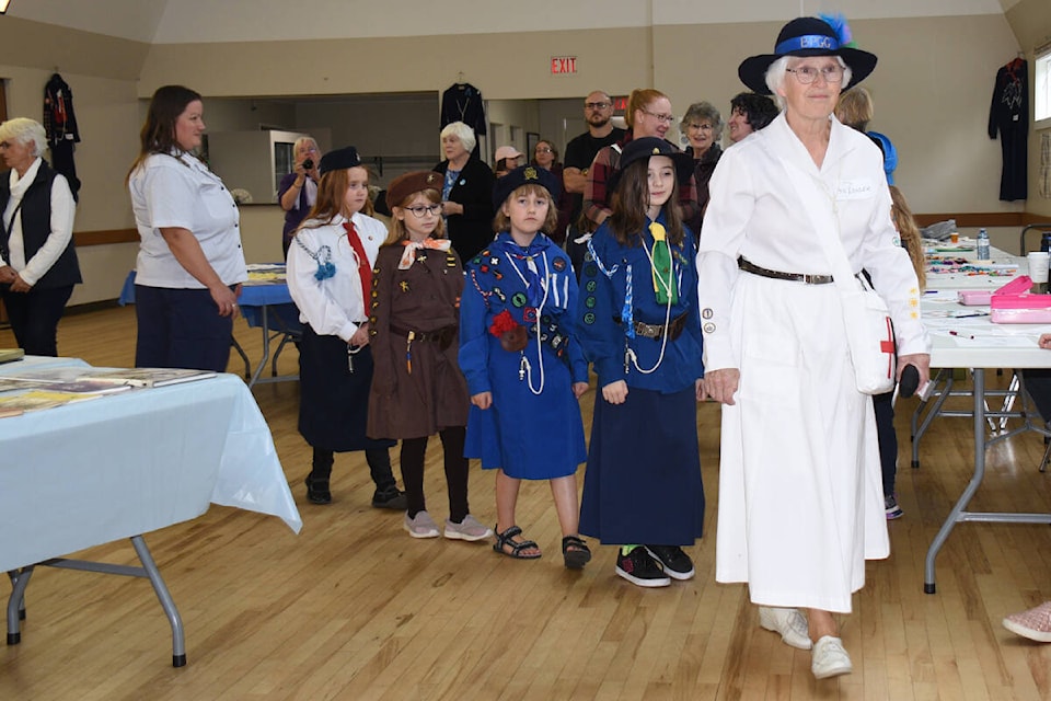 Sally Pilyk, right, of Chemainus leads a group of Embers clad in vintage Girl Guides of Canada uniforms during a centennial celebration Oct. 14, 2023 in Port Alberni. (SUSAN QUINN/ Alberni Valley News) 