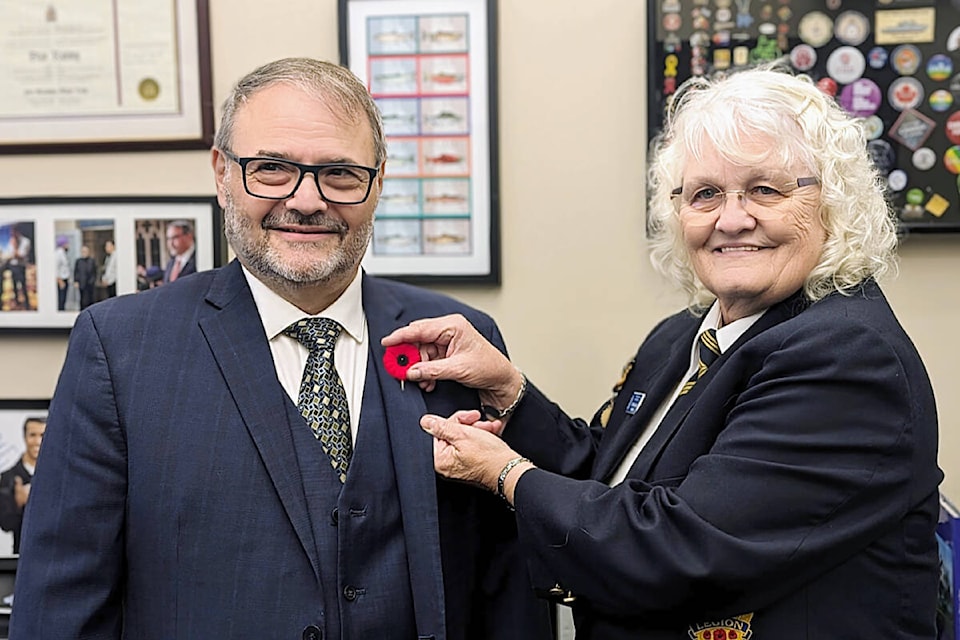 City of Maple Ridge Mayor Dan Ruimy receives the first poppy of the 2023 campaign from Royal Canadian Legion Branch 88 president Judy Ballard on Wednesday, Oct. 25. (Special to The News) 