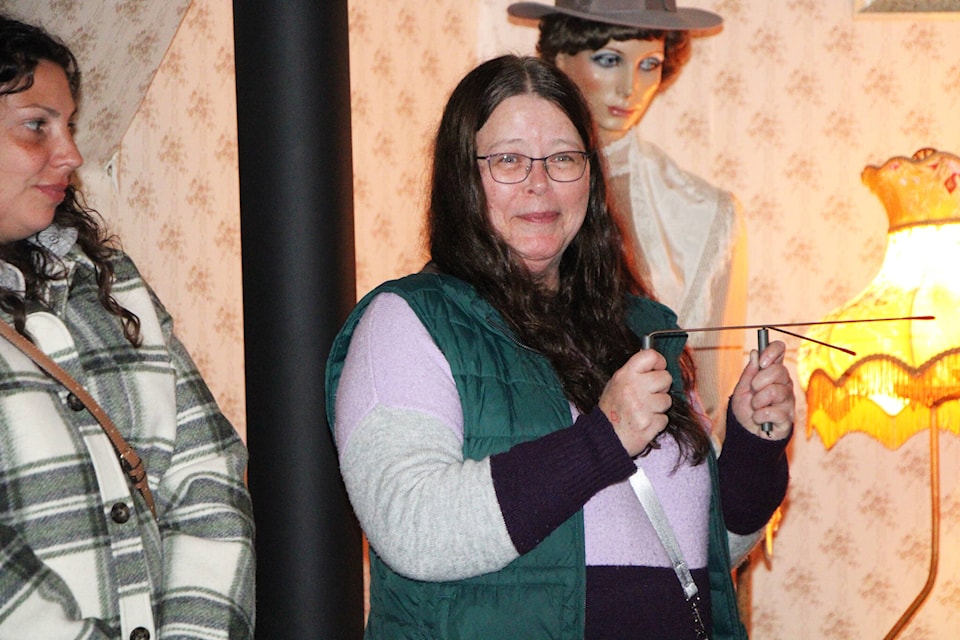 100 Mile Free Press reporter Fiona Grisswell uses a pair of dowsing rods to attempt to communicate with Lady Eleanor, a ghost said to haunt the 108 Mile Heritage Site. (Patrick Davies photo - 100 Mile Free Press) 