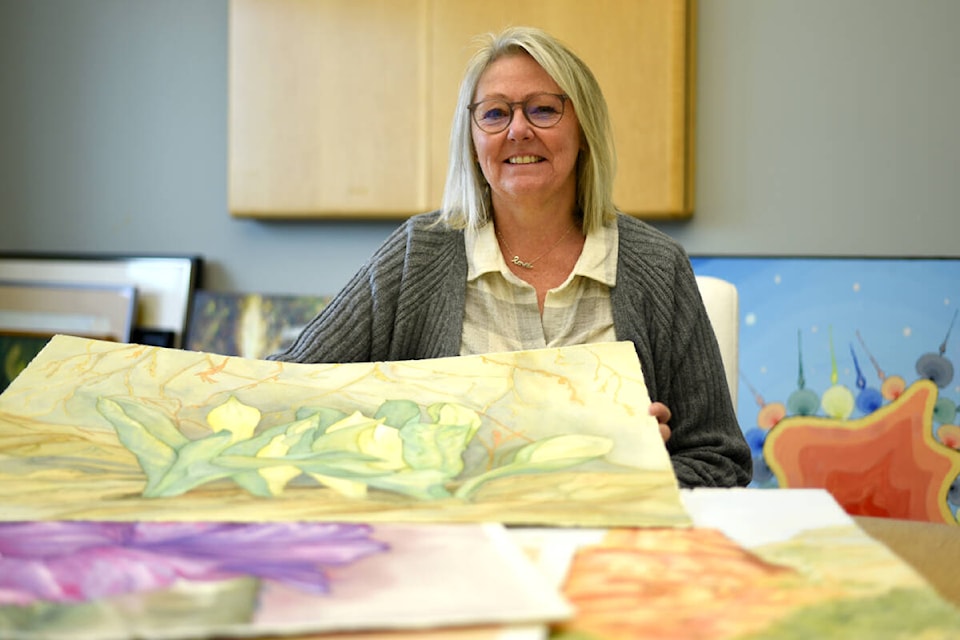 Melissa Martin, arts administrator with the Community Arts Council of the Alberni Valley, shows some of Alice Chiko and the late Jim Kermeen’s artwork that are part of the inaugural Cork and Canvas event. (Oct. 25, 2023) (SUSAN QUINN/ Alberni Valley News) 