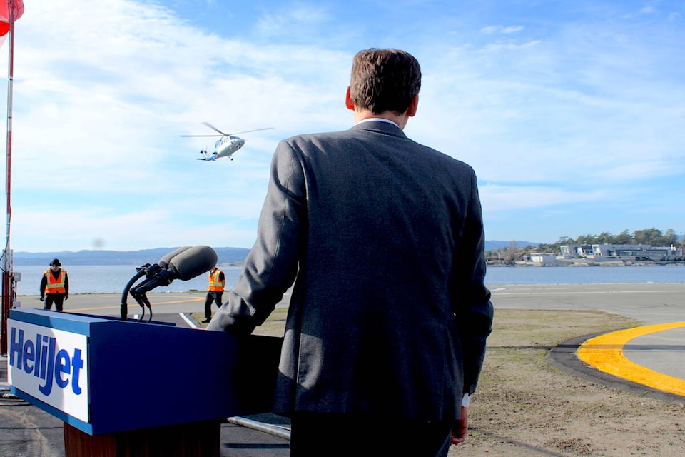 Premier David Eby watches as a helicopter lands in Victoria on Oct. 31. (Jake Romphf/News Staff) 