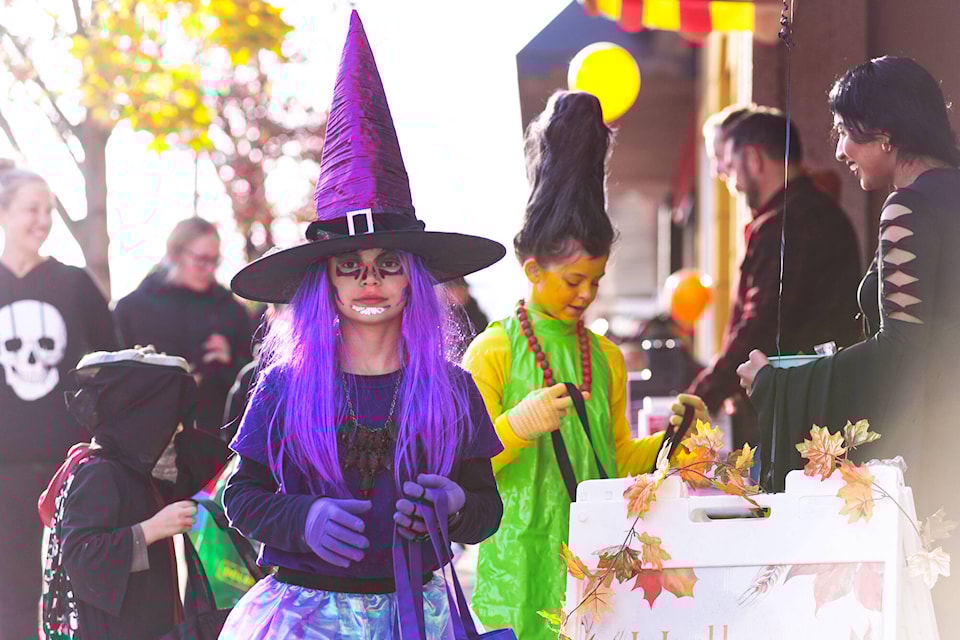 Sisters April Bergen, dressed as a witch, and Brooklyn Bergen as Marge Simpson, collect sweets on the Downtown Salmon Arm Halloween Treat Trail on Tuesday, Oct. 31, 2023. (Lachlan Labere-Salmon Arm Observer) 