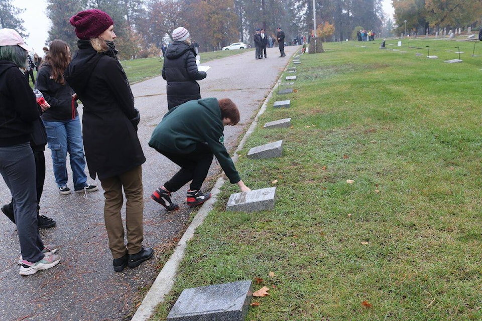 Students place poppies on the headstones of Canadian veterans in both World Wars at the Pleasant Valley Cemetery in Vernon, Tuesday, Nov. 2. (Bowen Assman- Morning Star Photo) 