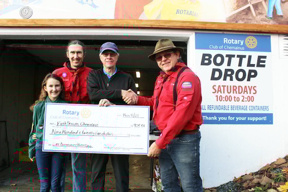The First Chemainus Scout Group is the Rotary Club of Chemainus bottle drop recipient for October. The group, represented by Jeff Moore and Martin Leigh, along with Ella-blue Moore, receives a cheque for $925.58 from the Rotary Club’s Tom Andrews. (Photo by Don Bodger) 