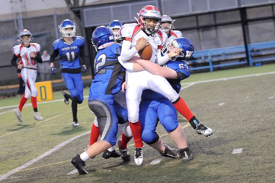 Ballenas Whalers defensive lineman Cole Campbell and linebacker Spencer Jordan wrap their arms around a John Barsby Bulldogs player. (Michael Briones photo) 