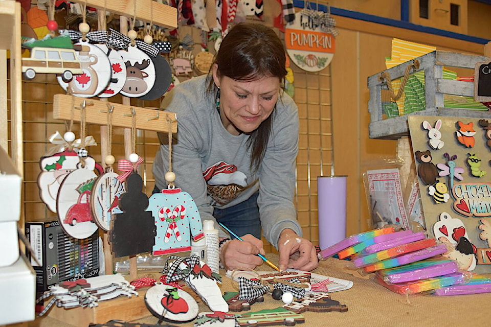 Melanie Salvatore of Party in a Box, paints her next piece - and herself - to keep her shelves well-stocked throughout the Christmas Craft and Trade Fair at Eagle River Secondary on Saturday, Nov. 18. 