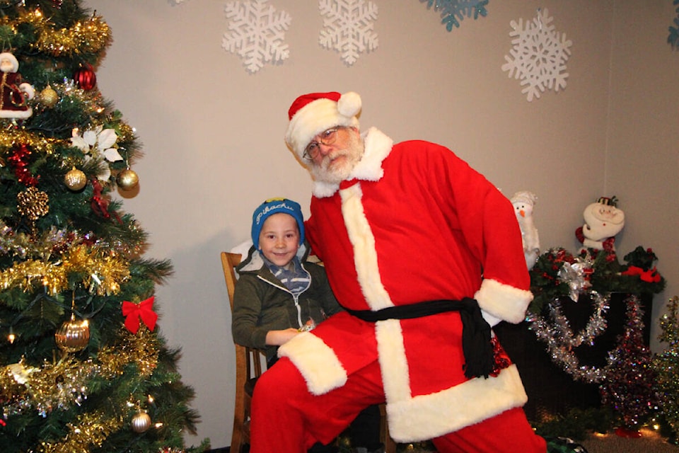 Kruz Bevaart laughs as Santa Claus pretends to sit on his lap at the Breakfast with Santa hosted at the Red Rock Grill. (Patrick Davies photo - 100 Mile Free Press) 