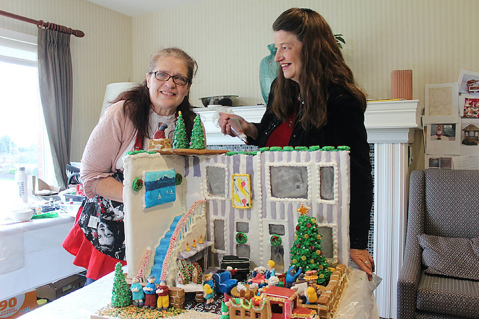 Margie Edwards (left), director of administrative services at Parkwood Place and Cheryl Chalifour (right), executive director have spent hundreds of combined volunteer hours creating their entry for Habitat for Humanity’s Gingerbread Showcase. (Samantha Duerksen/Black Press Media) 