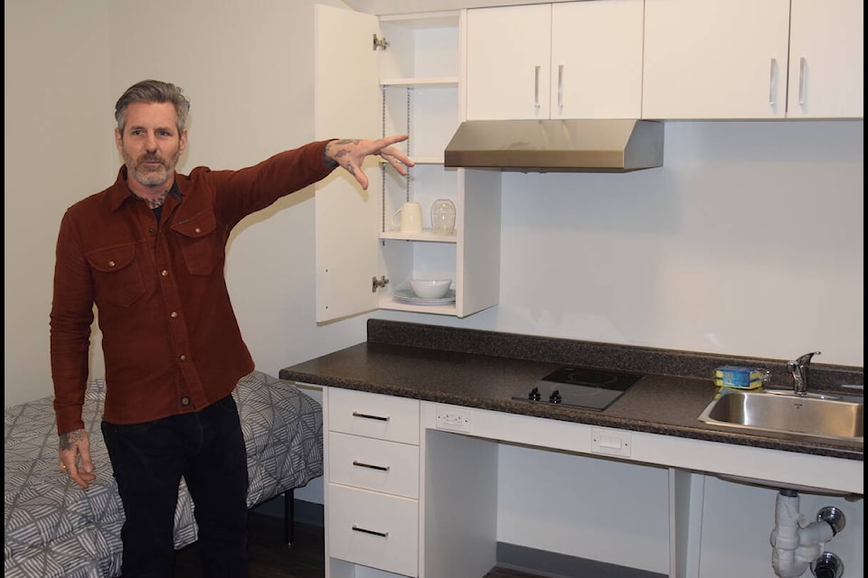Avery Taylor, director of operations for PHS in Victoria, gives Juniper visitors a tour of one of the units in the supportive housing building. (Brendan Mayer/News Staff) 