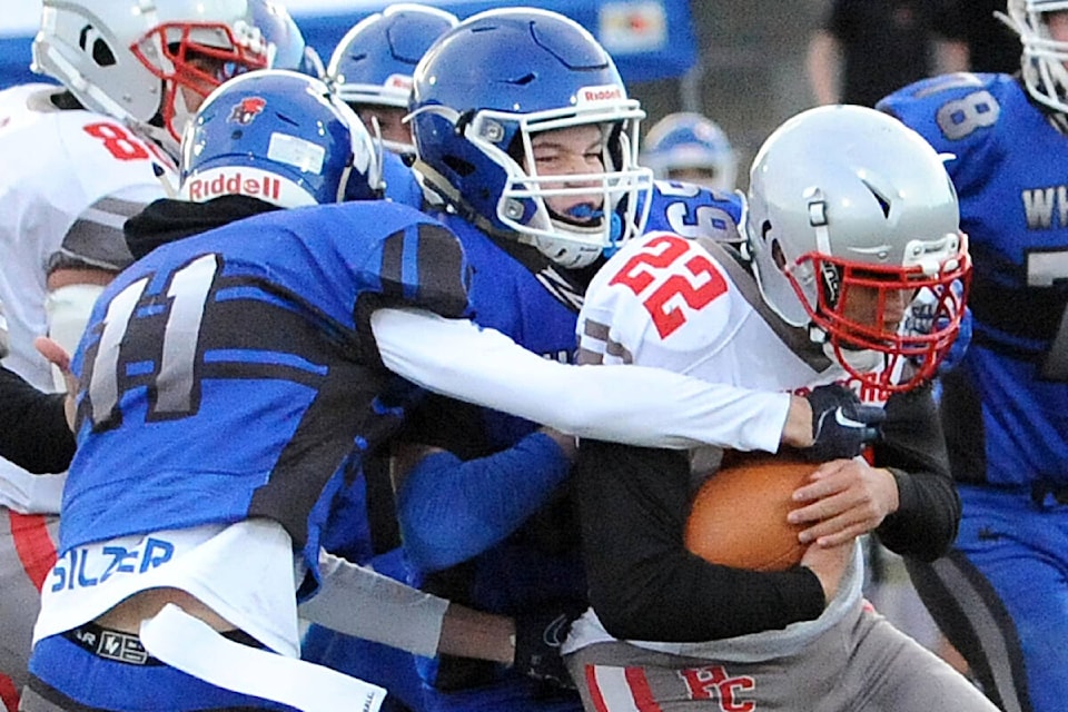 Ballenas Whales outside linebacker Noah Silzer (11) and defensive lineman Matthew Everatt stop Holy Cross Crusaders quarterback Luc Fillon. (Michael Briones photo) 