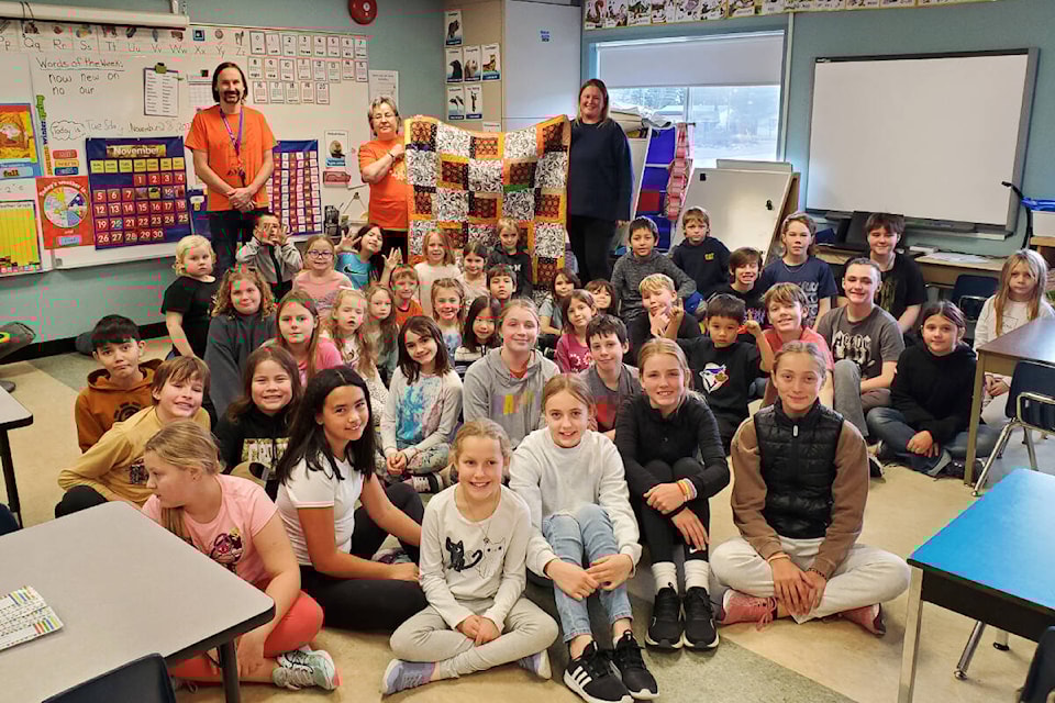 Orange Shirt Day Society founder Phyllis Webstad accepts a quilt for a residential school survivor created by students at Cataline Elementary School with help from quilters in Williams Lake. (Monica Lamb-Yorski photo - Efteen) 