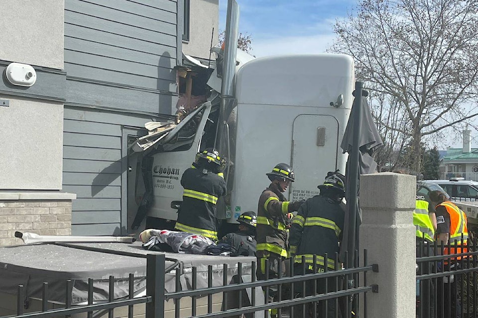 Kelowna firefighters assess the damage after a semi-truck crashed into a home at Cameron Avenue and Gordon Drive on April 11, 2023. (Gary Barnes/ Capital News) 