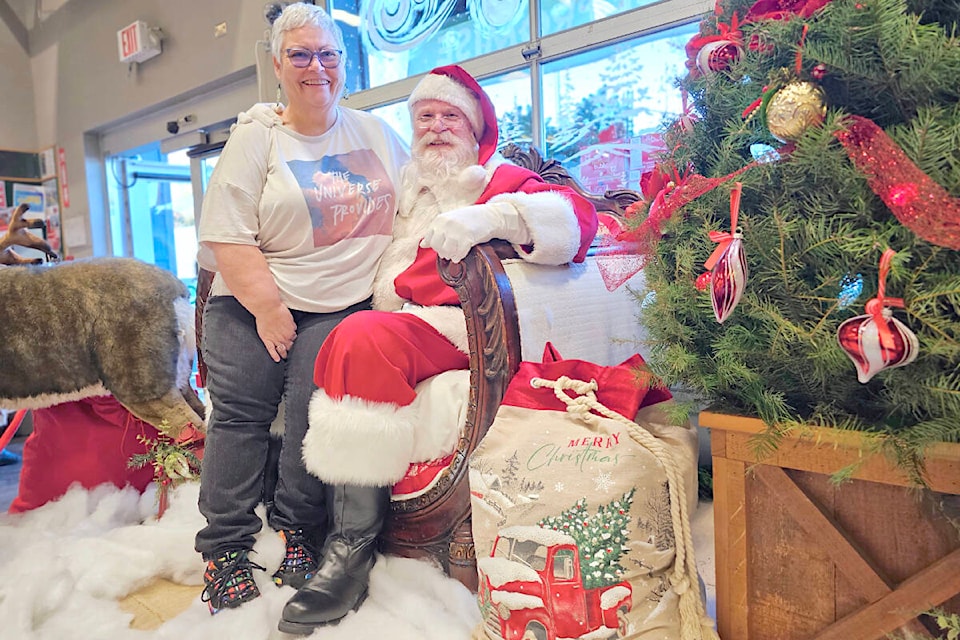 When Santa invited Laurie Parker from Aldergrove to have a seat, she accepted. It was the Aldergrove Save On Foods by-donation photos with Santa on Saturday, Nov. 25, with all proceeds going to the ‘Giving Tree’ Christmas campaign for seniors at Jackman Manor. (Dan Ferguson/91ԭ Advance Times) 