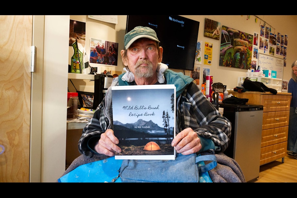 Bill Tyschuk shows off the recipe book he published in a photo taken on Nov. 28. (Jim Elliot/Yukon News) 