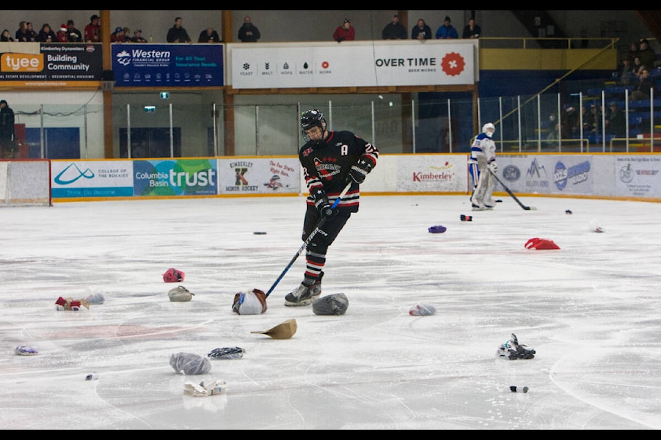 Kade Leskosky helps collect the hats, toques and mitts that Nitros fans flung onto the ice to donate to the Kimberley Food Bank. Paul Rodgers photo. 