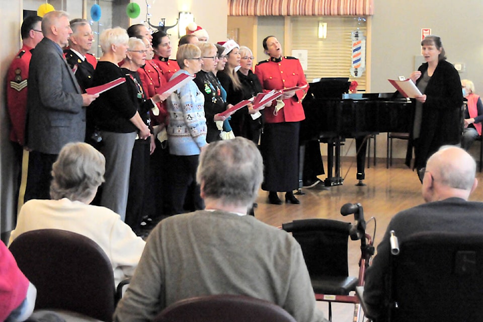 The Oceanside RCMP detachment choir sings Christmas carols to residents at Stanford Seniors Village in Parksville. (Michael Briones photo) 