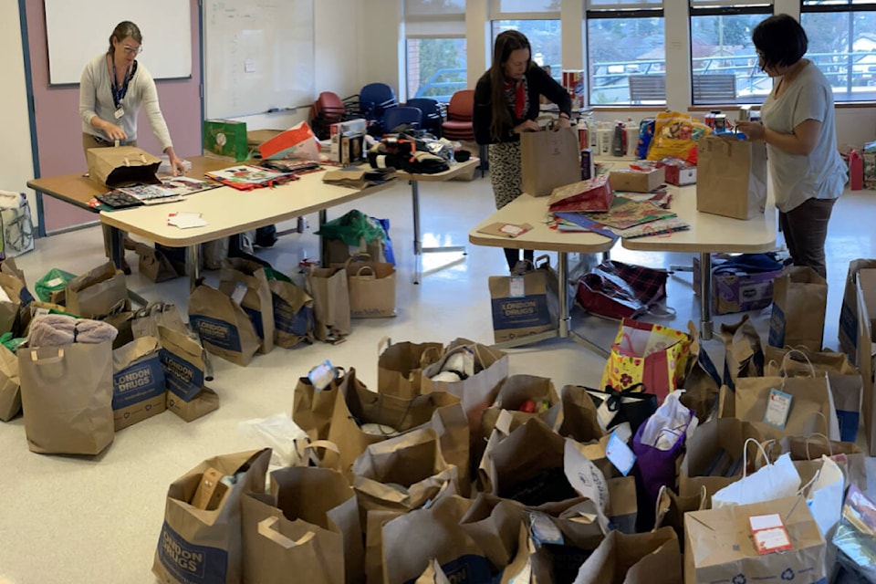 Cathy Bailey, Emily Pridham, and Tania Fritz wrap gifts for the Christmas program that ensures seniors in need receive something Christmas morning. (Courtesy Eldercare Foundation) 