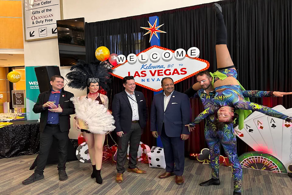  International Airport CEO Sam Samaddar (fourth from left) and WestJet executive Riccardo Simonelli look on as entertainers help celebrate the launch of direct flights between  and Las Vegas during a media event on Dec. 15, 2023. (Lauren McNeil/Capital News) 