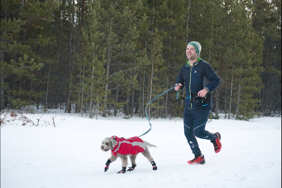 A runner crosses the finish line with his dog at the Winter Solstice Run on Dec. 16. (Patrick Egwu/Yukon News) 