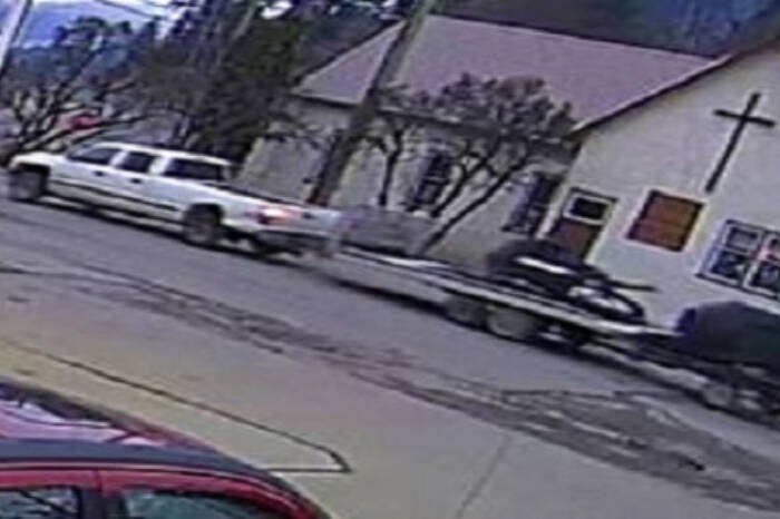 An image of a white pickup truck towing trailers loaded with a snowmobile and an ATV, which were stolen from a Lumby business at 7:30 a.m. Saturday, Nov. 25, 2023. Police are actively searching for the suspect vehicle pictured here. (RCMP photo) 