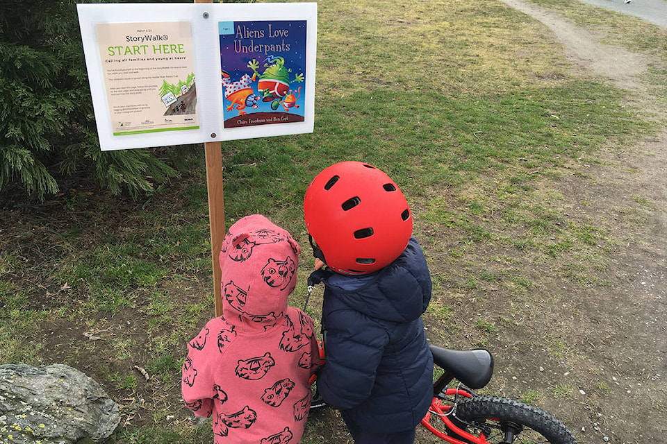 A pair of youngsters check out a StoryWalks page in Chilliwack’s Vedder Park in 2021. This year, Read White Rock/Surrey has made five StoryWalks kits available for groups that want to create similar literacy-boosting experiences on the Semiahmoo Peninsula to borrow. (Jenna Hauck file photo) 